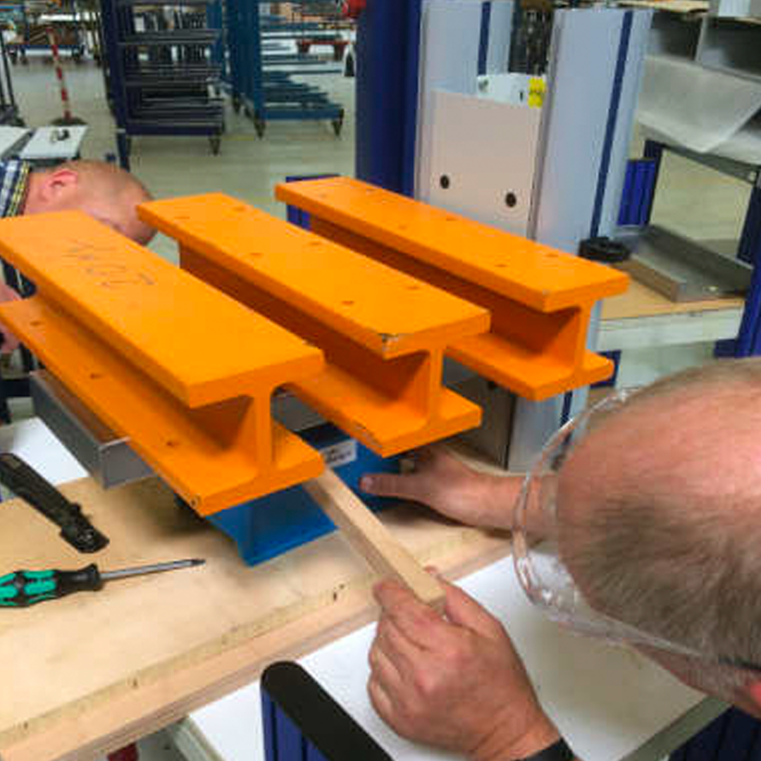 Two men stress-testing prototype of technical furniture